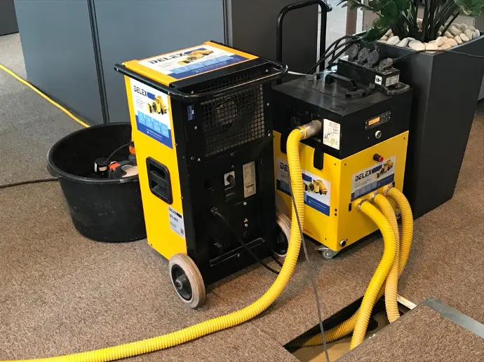 Computervloer drogen Een installatie voor een ruimte onder een zwevende vloer te drogen na een grote waterlek, deze installatie werd geplaatst door Delex.
