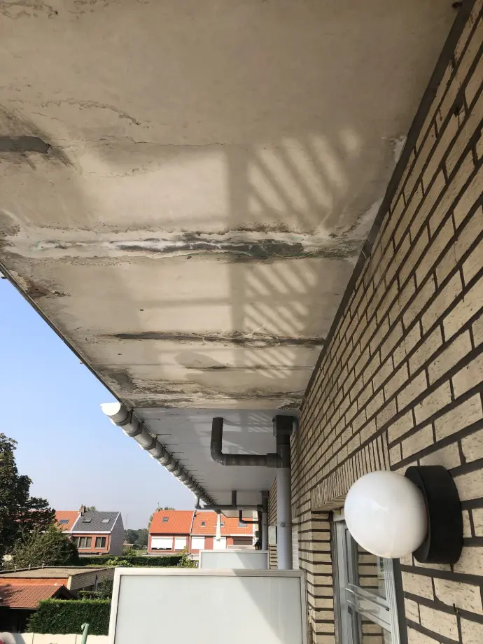 Schade aan een terras Waterschade aan de onderzijde van een terras veroorzaakt door een lek.