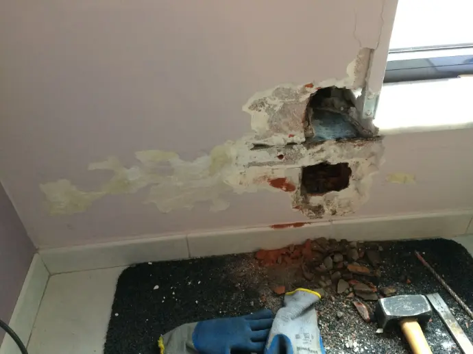 Gevonden lek na het open maken van een muur. Een muur opengemaakt tijdens een bouwpathologie om een lek te vinden, uitgevoerd door Delex